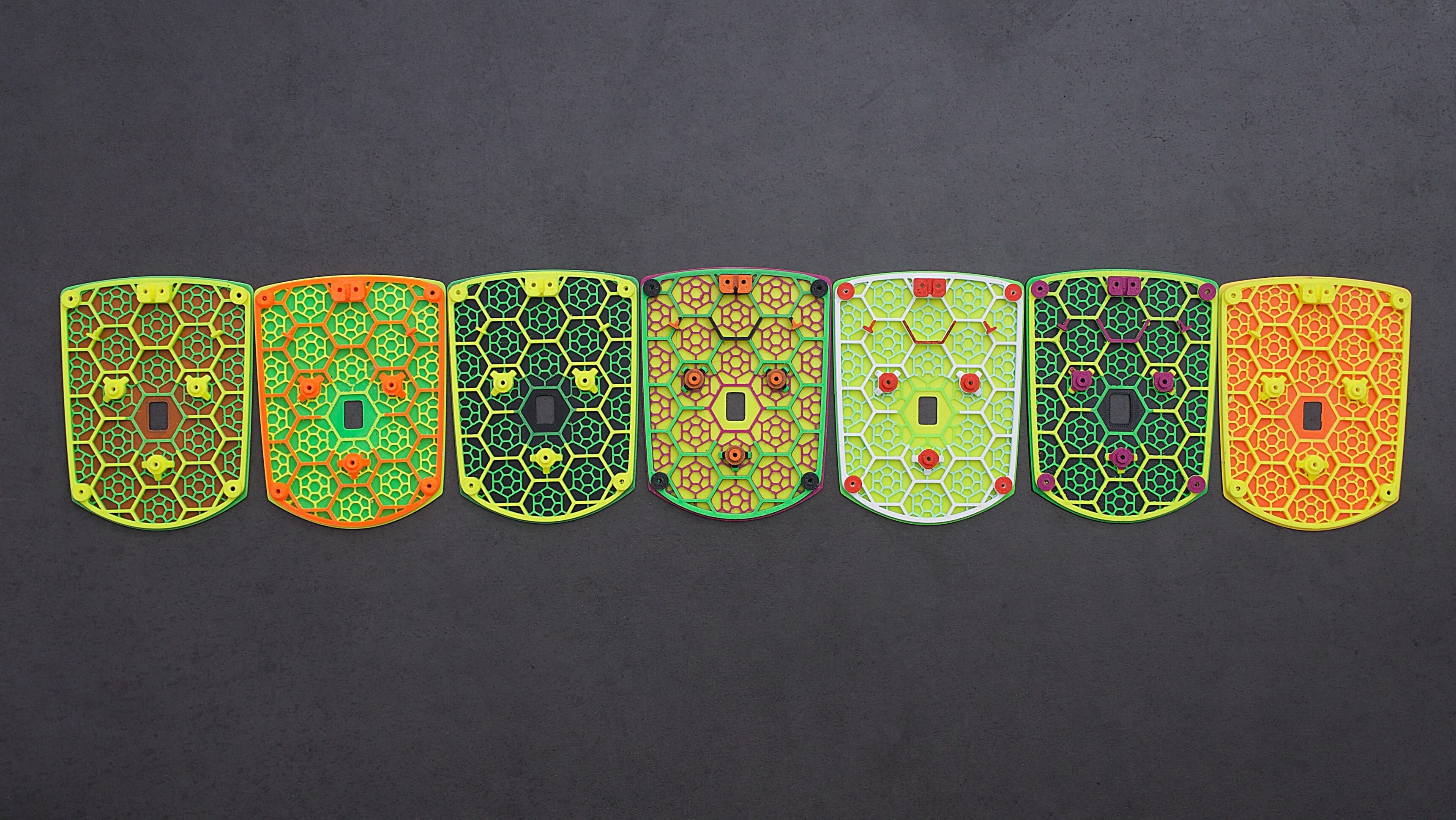 This picture shows seven different 3D printed multicolored bottom shells for the Zaunkoenig M1K.